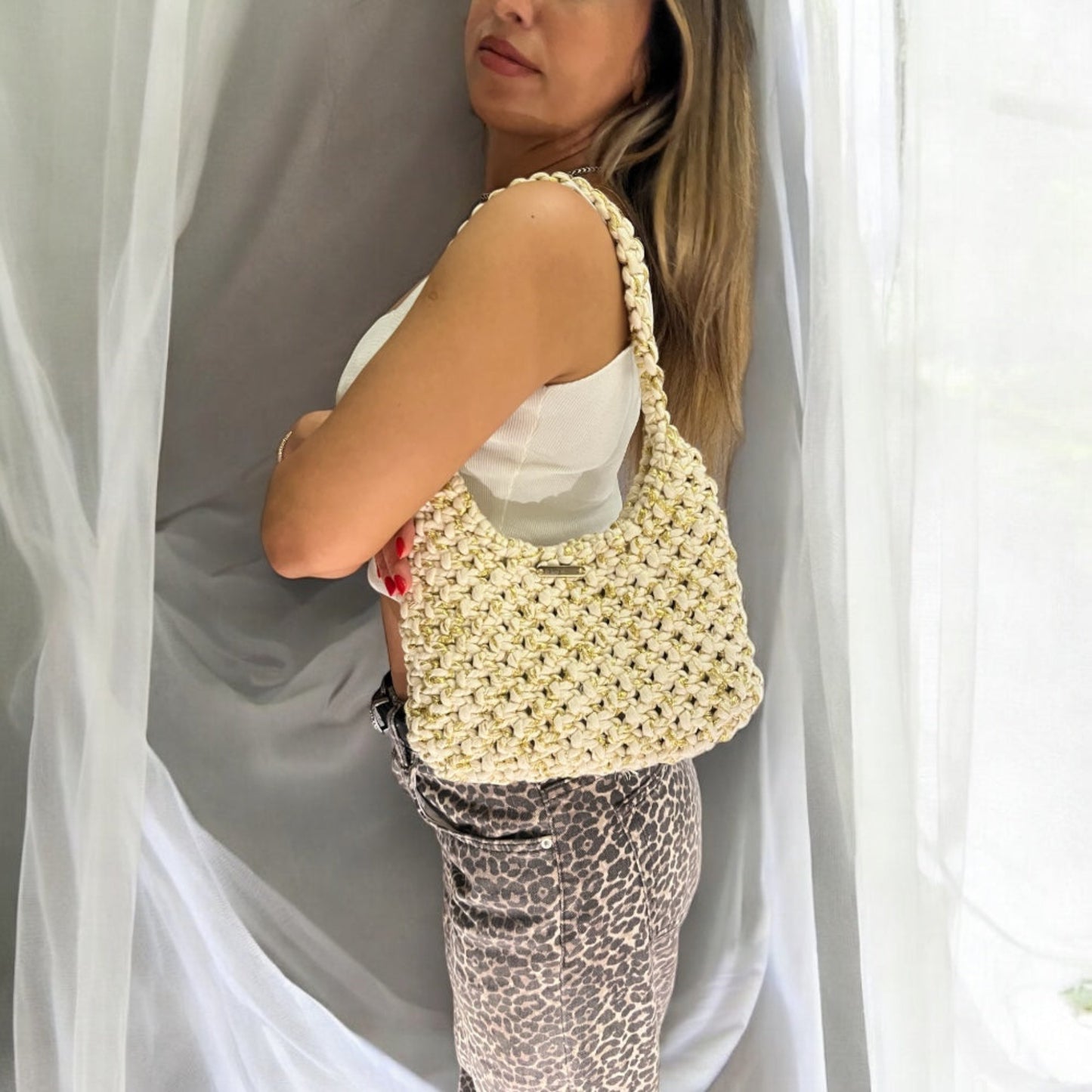Beige gold handmade macrame shoulder bag worn on model, luxury boho chic half moon purse