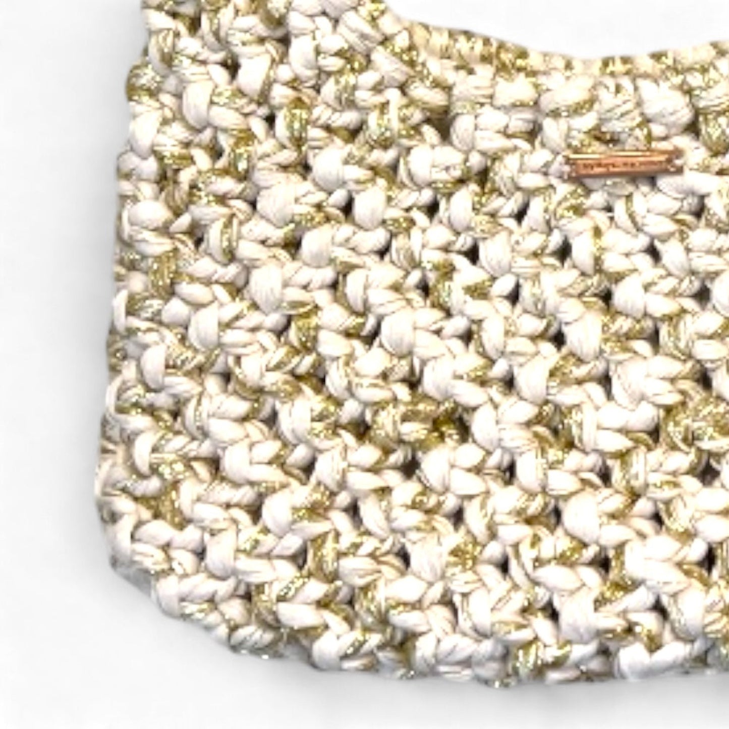 Extreme close-up of beige gold macrame weave with metallic thread, luxury handmade texture