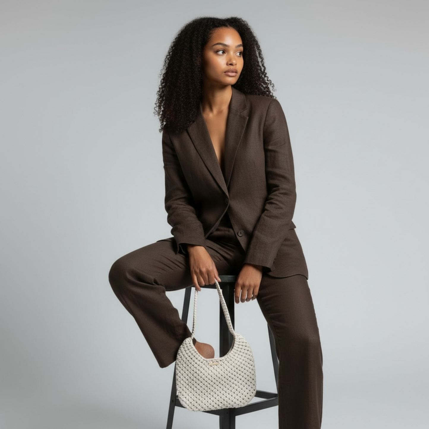 Beige handmade macrame bag styled with tailored brown outfit, modern elegant look