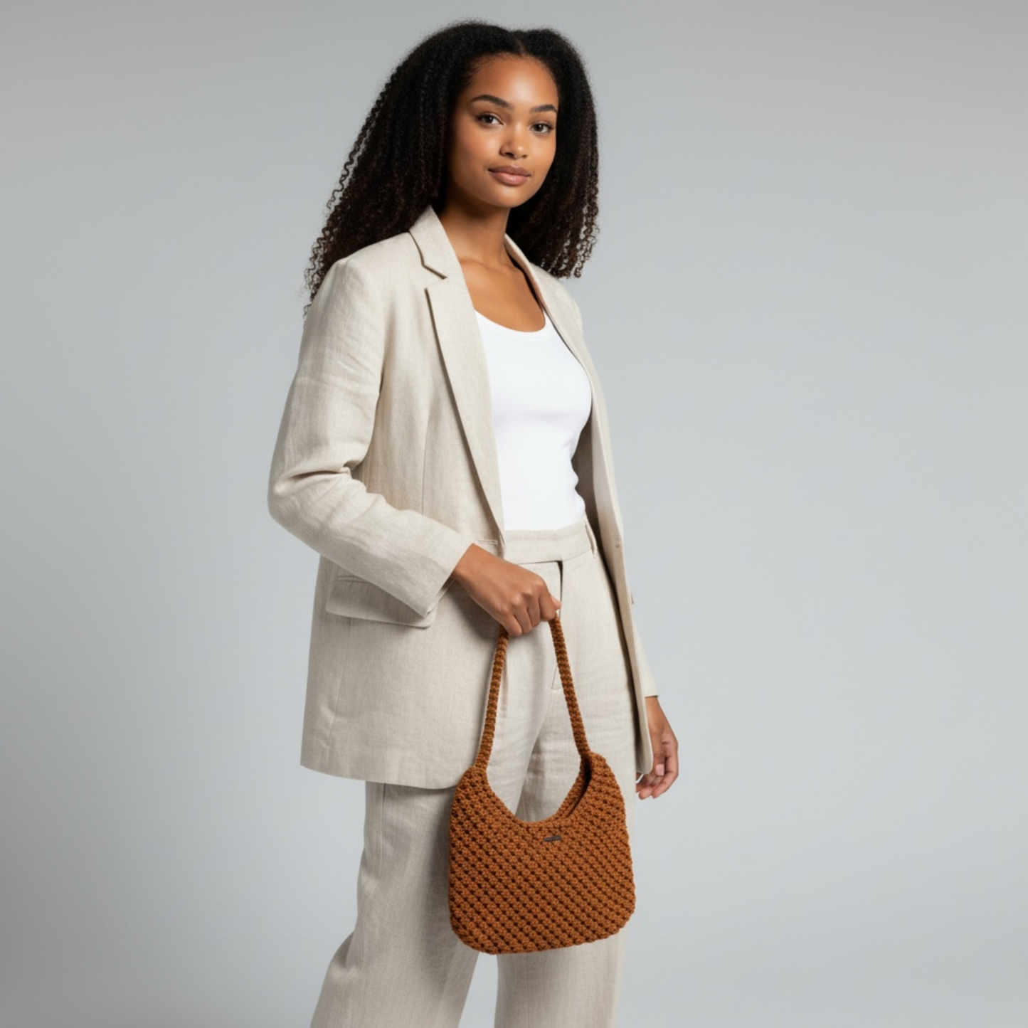 Burnt orange half moon bag styled with neutral suit, elegant handmade shoulder bag for modern minimal look