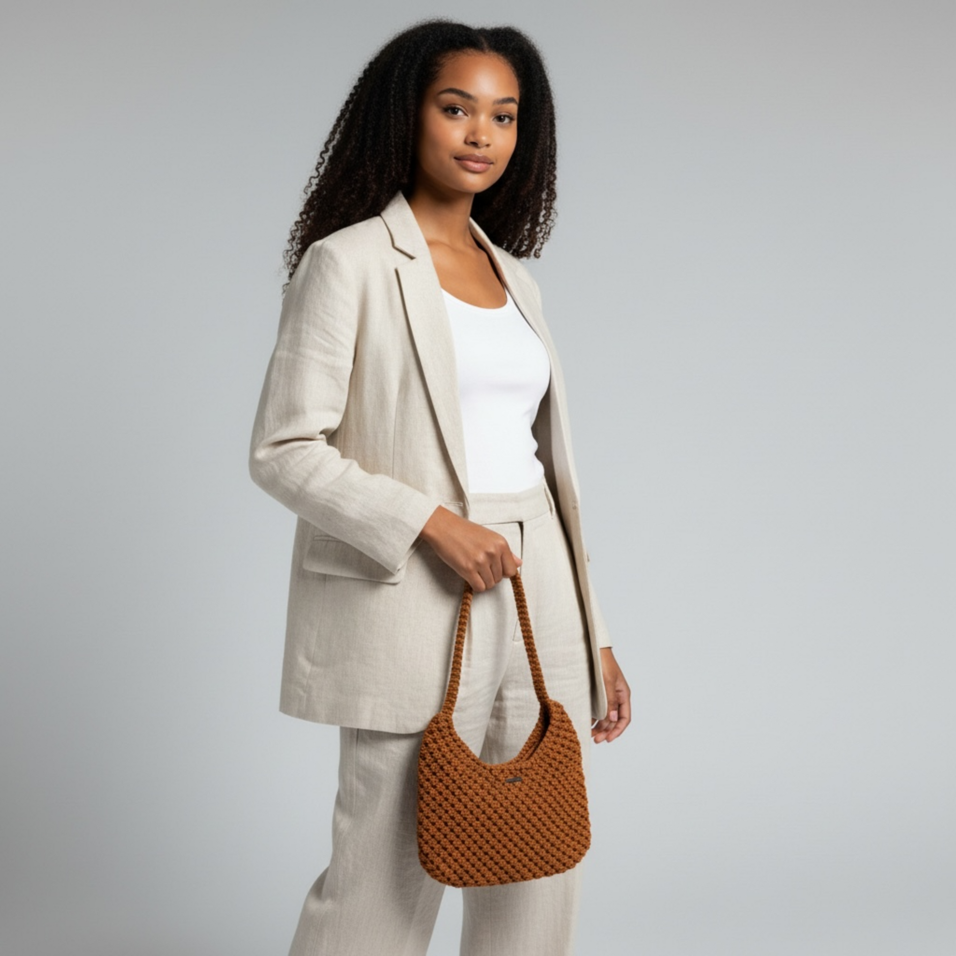 Burnt orange half moon bag styled with neutral suit, elegant handmade shoulder bag for modern minimal look