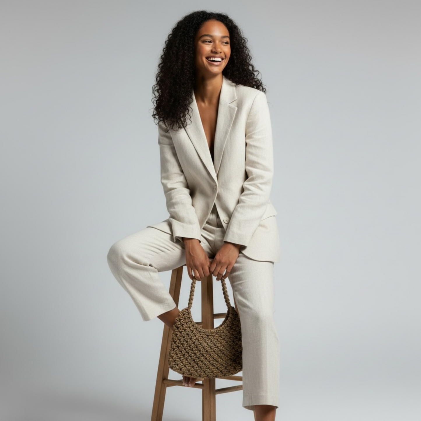 Caramel brown half moon bag styled in a relaxed seated pose with clean studio lighting