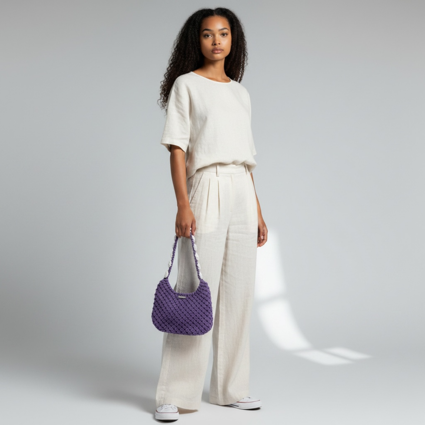 Woman wearing dusty lavender crochet shoulder bag, minimalist half moon handbag styling