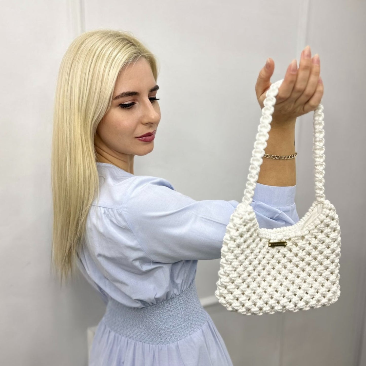 Close styling of ivory white woven bag with elegant casual outfit